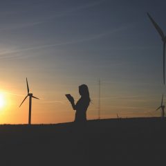 silhouette-of-woman-holding-book-near-windmills-636335